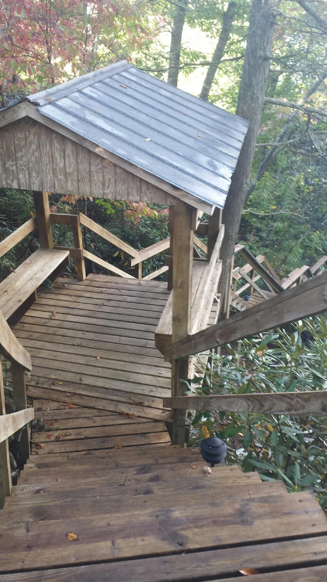 Metal roofed shelter over wooden steps on a wooded walkway — Skylight Repair & Installation work by our crew in Ellston