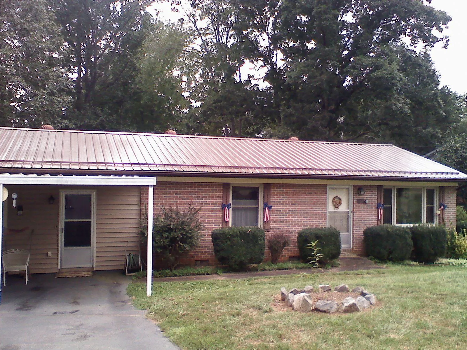 Bronze metal roof and carport on a brick ranch home — Roof Repair work by our crew in Ellston
